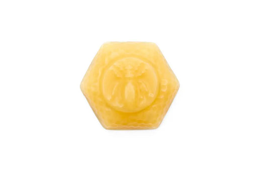 Small hexagon beeswax block with a raised bee and honeycomb border on a white background.